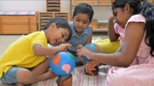 Children exploring globes together in a classroom, engaged in hands-on learning activities.